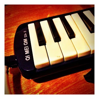 A black and white melodica keyboard on top of a wooden table.