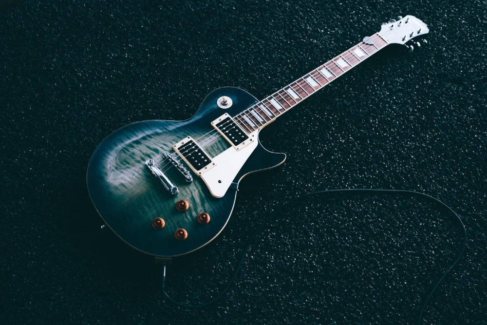 An electric guitar laying on the ground in the Ultimate Guide.