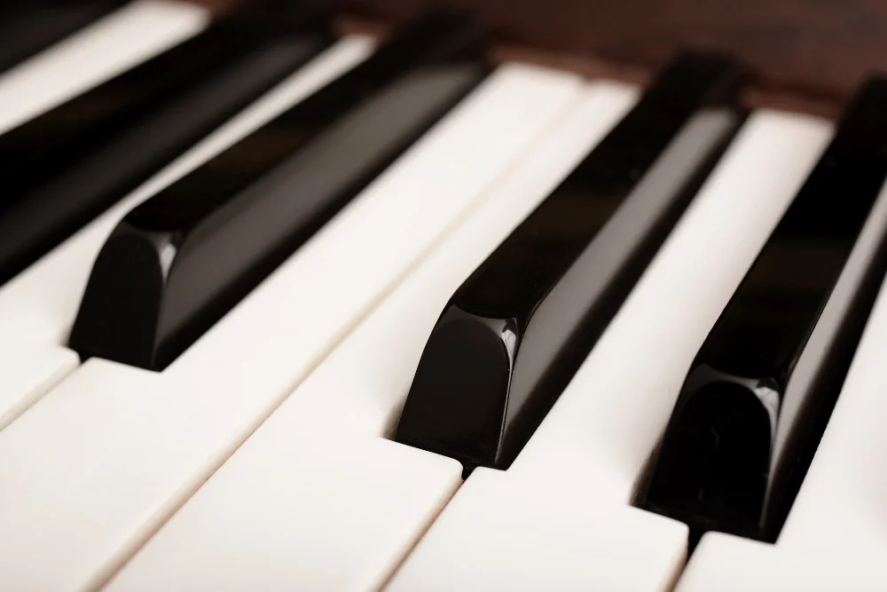 A close up of a piano keyboard with black and white keys, creating the perfect sound.
