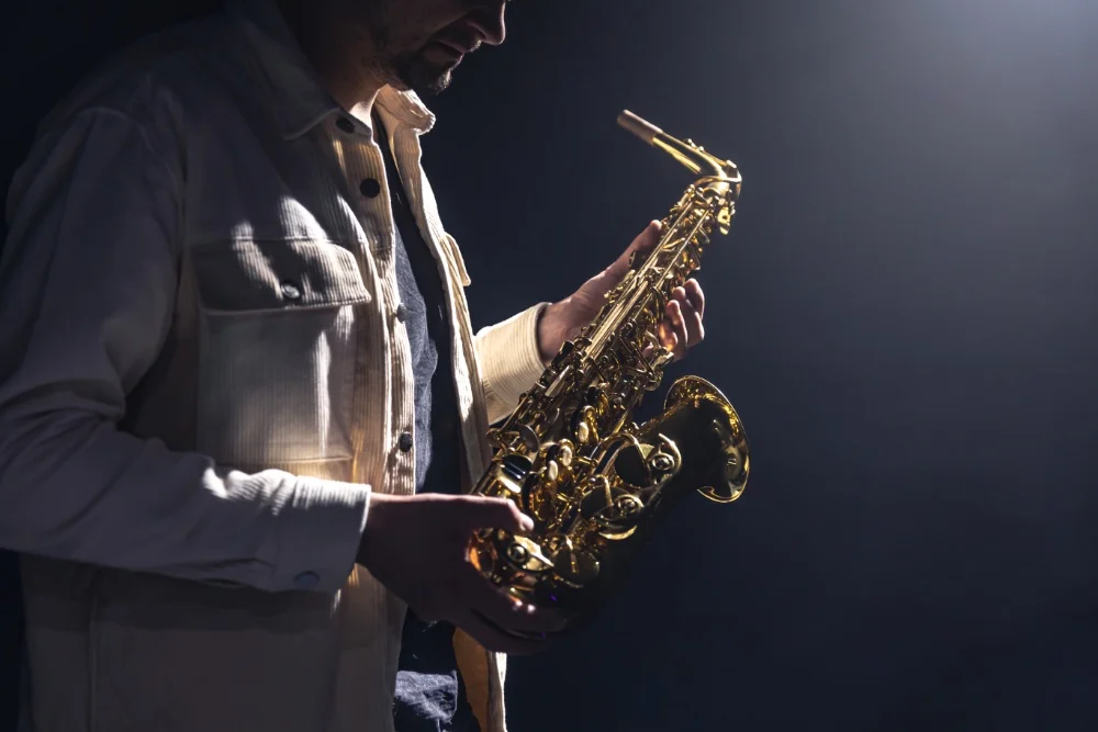 A man playing a saxophone on a dark background, creating the perfect sound.