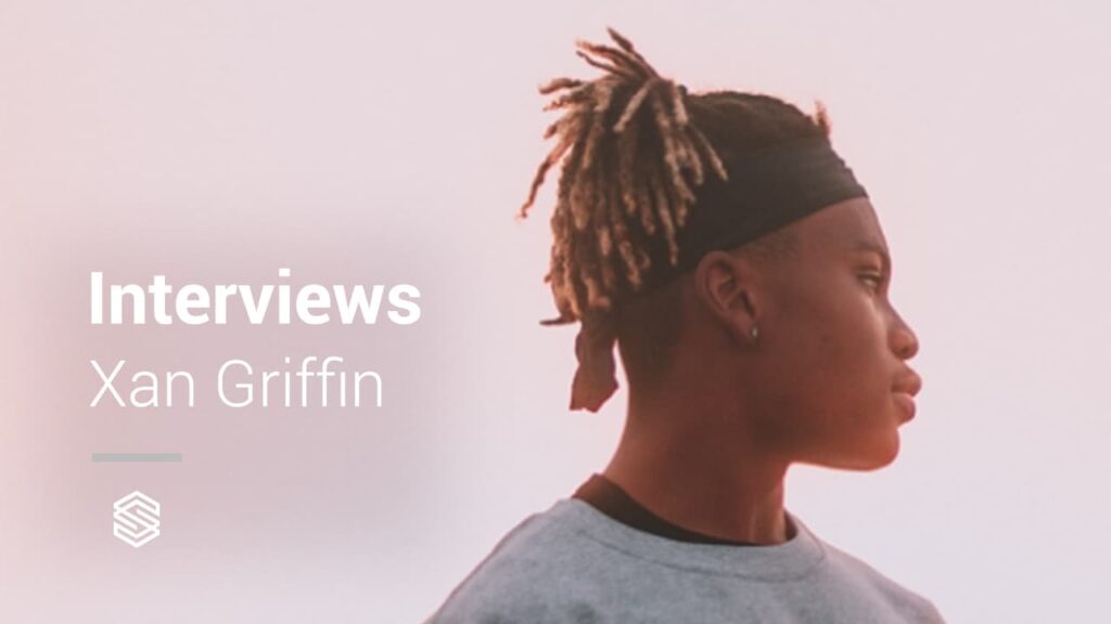 A man with dreadlocks in front of a background with the word "interviews" xan griffin.