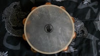 A wooden drum, resembling a tambourine, with a dragon design on it.