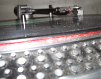 A turntable with red and black dots on it, exhibiting slight scratches.