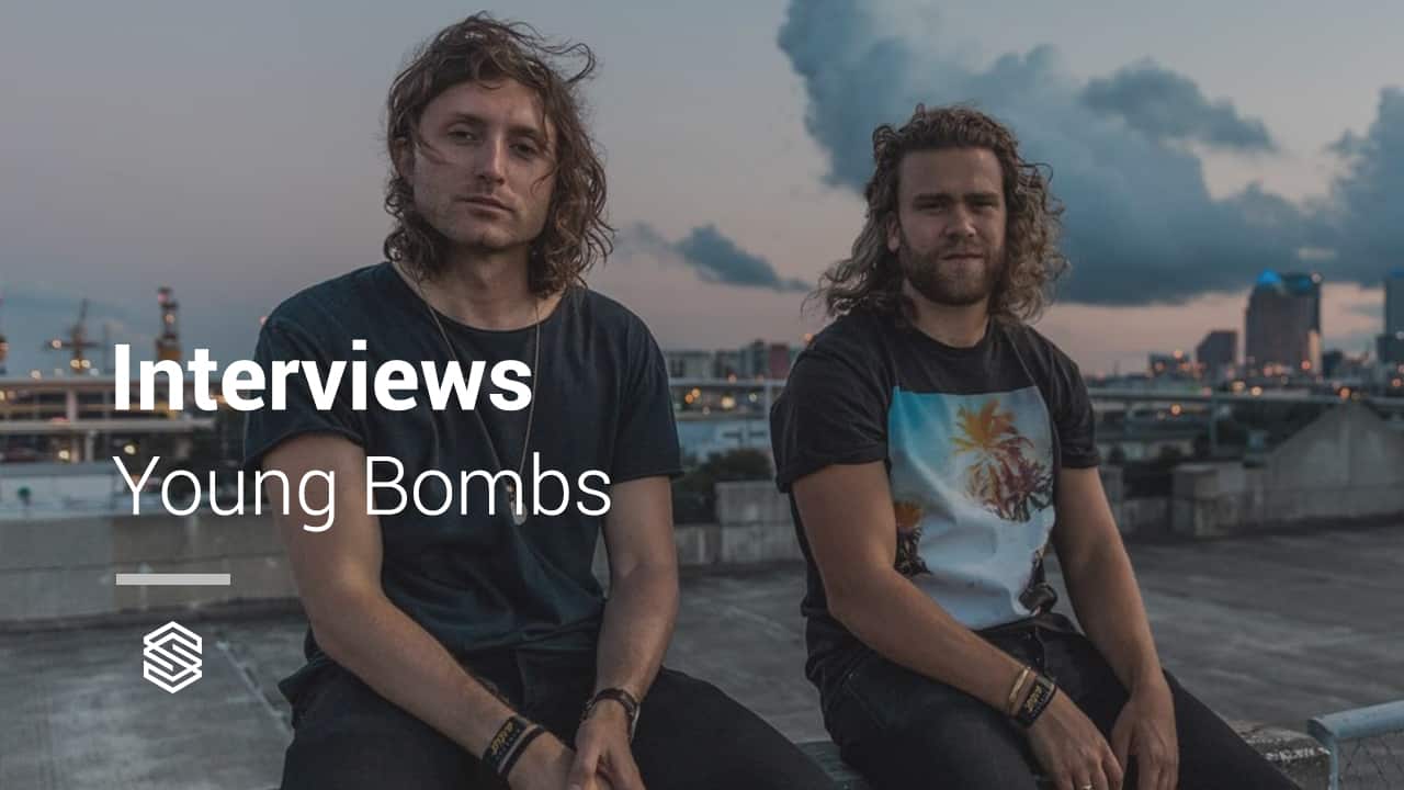 Two men sitting on a rooftop conducting interviews with Young Bombs.